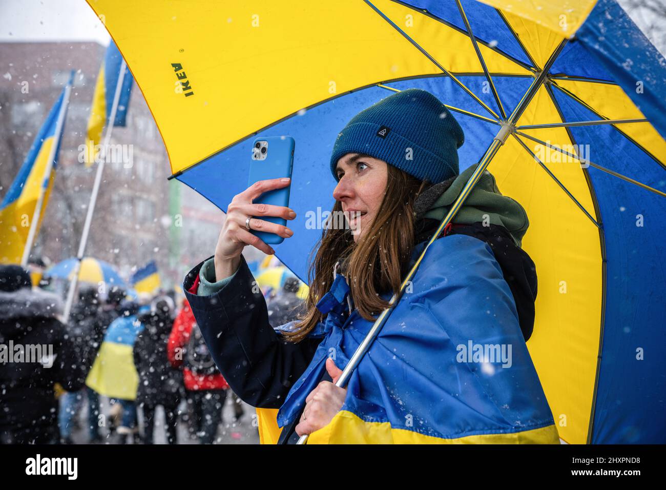 Toronto, Canada. 13th Mar 2022. Durante la dimostrazione, un manifestante scatta foto tenendo un ombrello a colori della bandiera Ucraina. Migliaia di marzo al Consolato degli Stati Uniti per un rally "No Fly zone" a Toronto, Canada. Le proteste globali sono state organizzate in tutto il mondo a seguito dell'invasione russa dell'Ucraina. (Foto di Katherine Cheng/SOPA Images/Sipa USA) Credit: Sipa USA/Alamy Live News Foto Stock