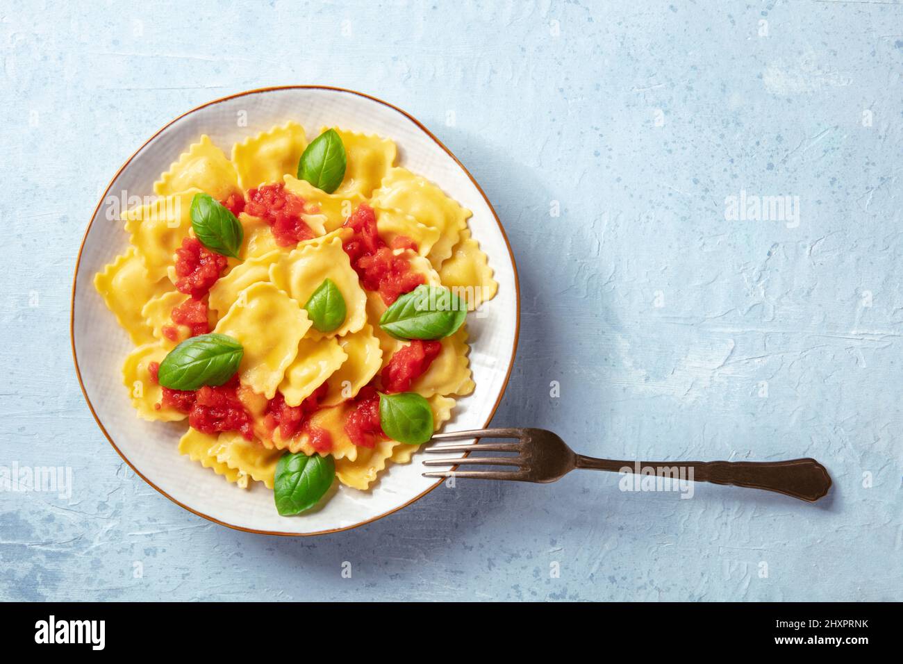 Ravioli con salsa di pomodoro e basilico. Un piatto di pasta farcita, sparato dall'alto con un posto per il testo Foto Stock