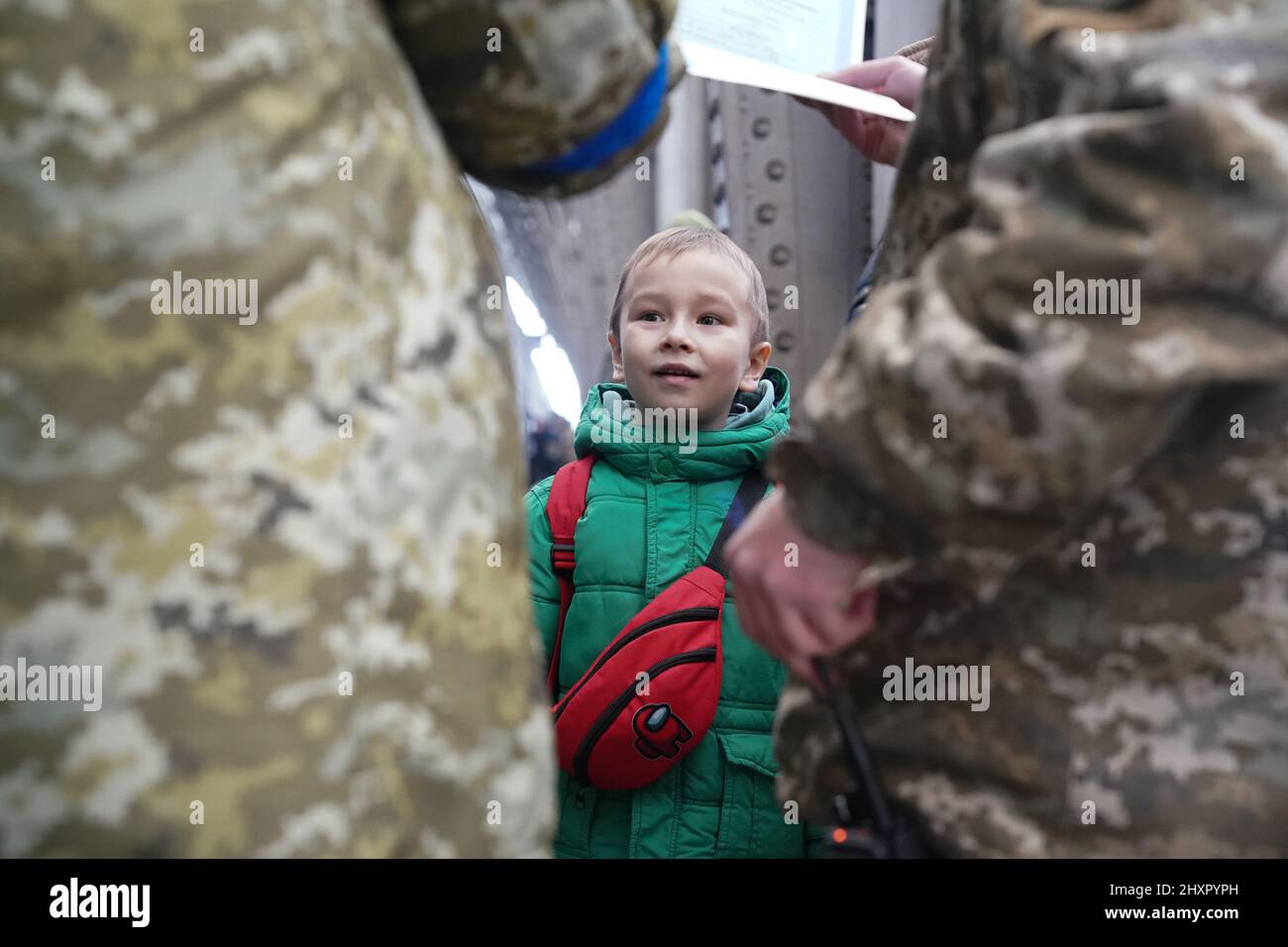 Lviv, Ucraina. 14th Mar 2022. Un bambino guarda avanti mentre i passaporti vengono controllati prima di abbaiare un treno per la Polonia, mentre i rifugiati ucraini si spostano attraverso la stazione ferroviaria di Lviv il 14 marzo 2022. Oltre 2,5 milioni di persone hanno lasciato l'Ucraina dall'inizio dell'invasione russa quasi tre settimane fa. (Credit Image: © Bryan Smith/ZUMA Press Wire) Foto Stock