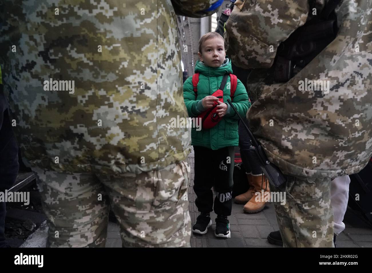 Lviv, Ucraina. 14th Mar 2022. Un bambino guarda avanti mentre i passaporti vengono controllati prima di abbaiare un treno per la Polonia, mentre i rifugiati ucraini si spostano attraverso la stazione ferroviaria di Lviv il 14 marzo 2022. Oltre 2,5 milioni di persone hanno lasciato l'Ucraina dall'inizio dell'invasione russa quasi tre settimane fa. (Credit Image: © Bryan Smith/ZUMA Press Wire) Foto Stock