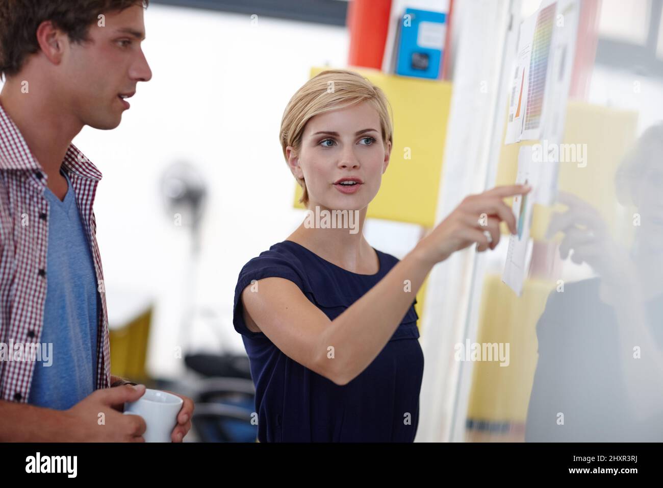 Il piano d'azione.... Scatto corto di una giovane donna d'affari che spiega qualcosa al suo collega in una lavagna bianca. Foto Stock
