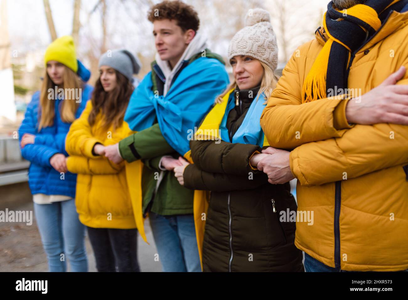 Manifestanti con bandiere blu e gialle ucraine che protestano contro la guerra in Ucraina per strada Foto Stock