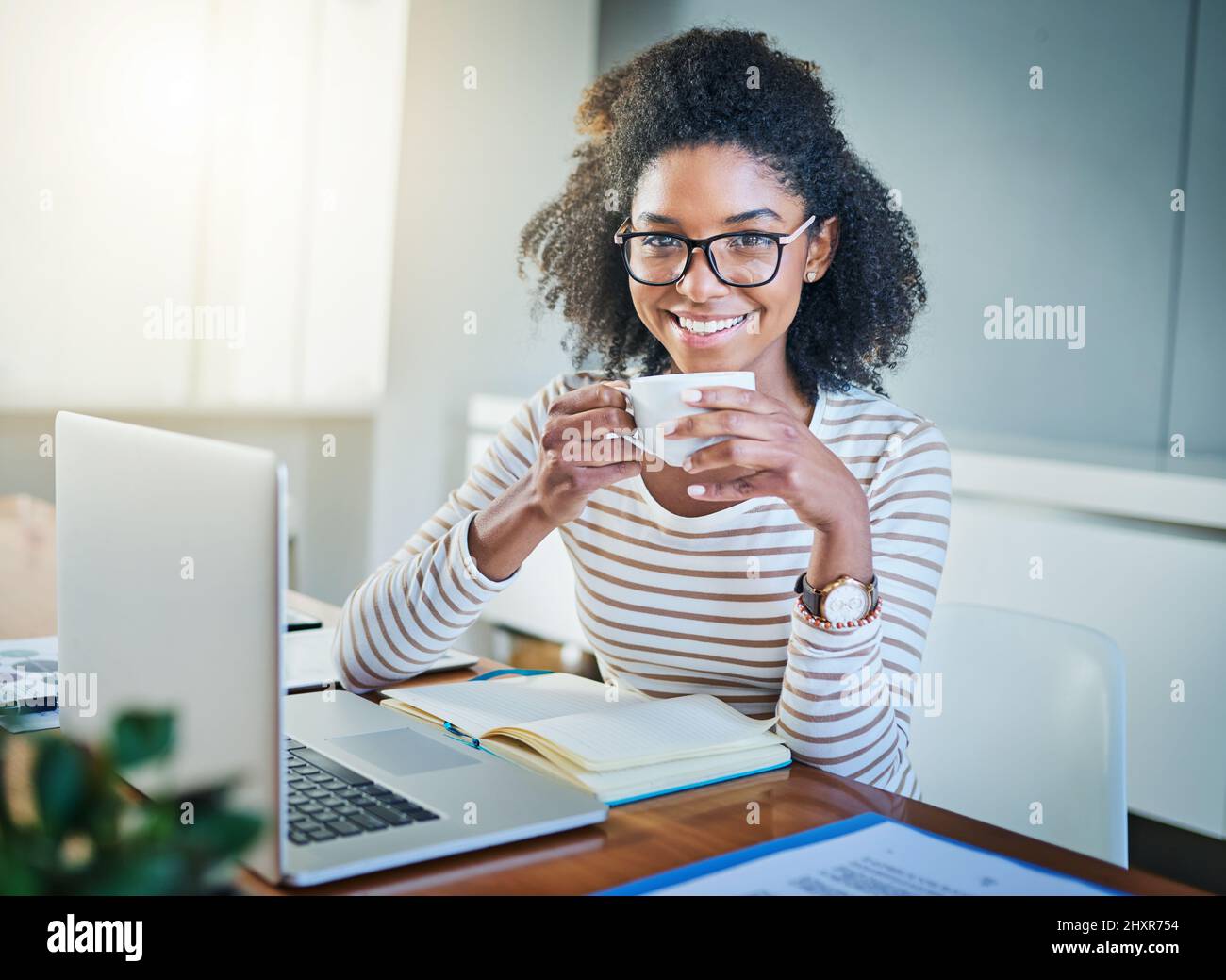 È stato un giorno così produttivo. Ritratto di una giovane donna che lavora su un notebook a casa. Foto Stock