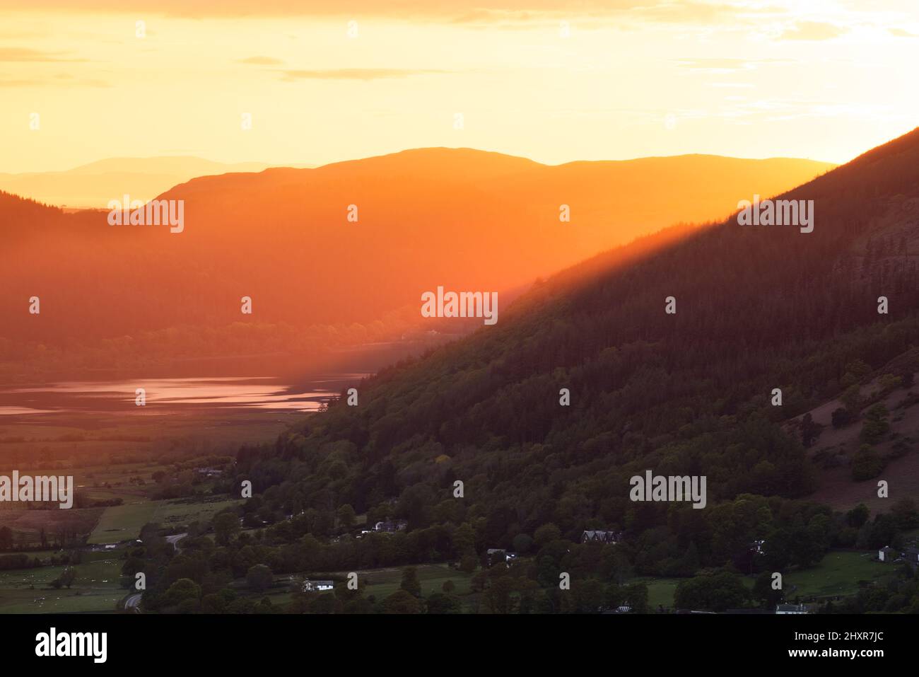 Splendidi raggi dorati di luce dalla sera che tramonta il sole che brilla attraverso le montagne nella valle. Keswick, Lake District, Regno Unito. Foto Stock