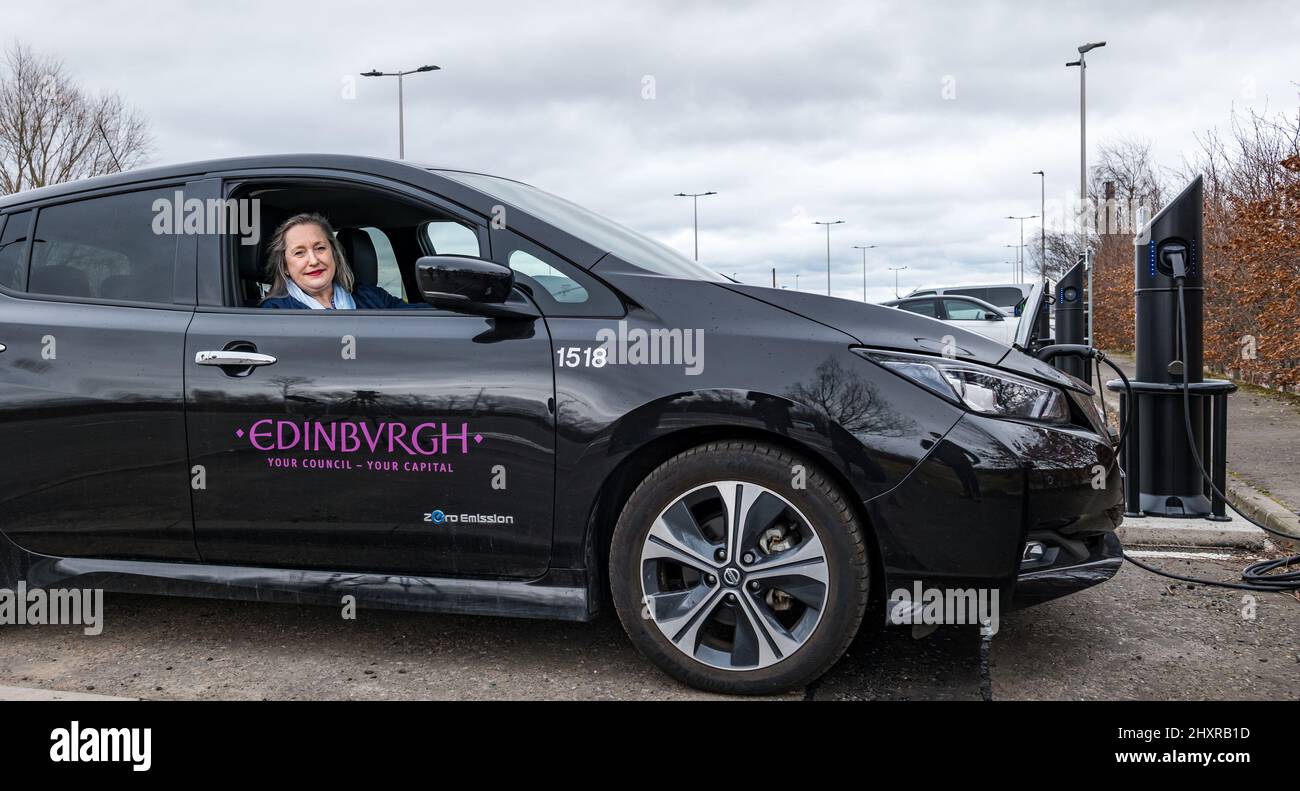 Ingliston Park & Ride, Edimburgo, Scozia, Regno Unito, 14 marzo 2022. Ingliston Park & Ride stazioni di ricarica per auto elettriche: Trasportatore dei trasporti e consigliere della città di Edimburgo, Lesley Macinnes vede come funzionano i nuovi caricatori con una City of Edinburgh Council Electric Car al parco e giro. Sono stati installati quindici nuovi caricabatteria da 7kwh per ospitare altri 30 veicoli elettrici nell'ambito del lancio di £2,2m in tutta la città. Foto Stock