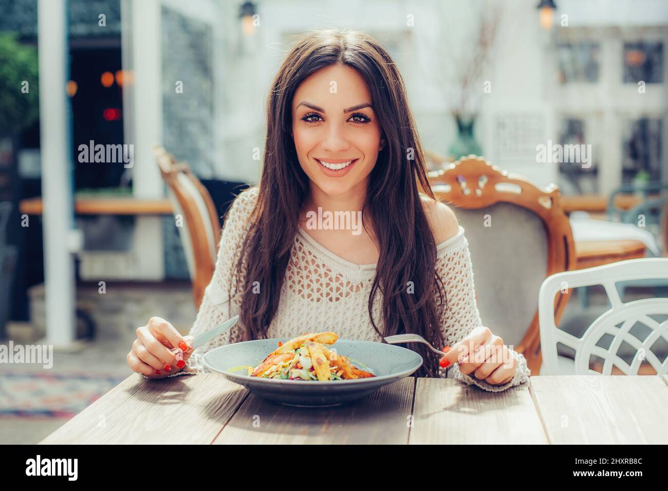 Giovane donna che si gusta il cibo in un ristorante, facendo la pausa pranzo. Primo piano Foto Stock