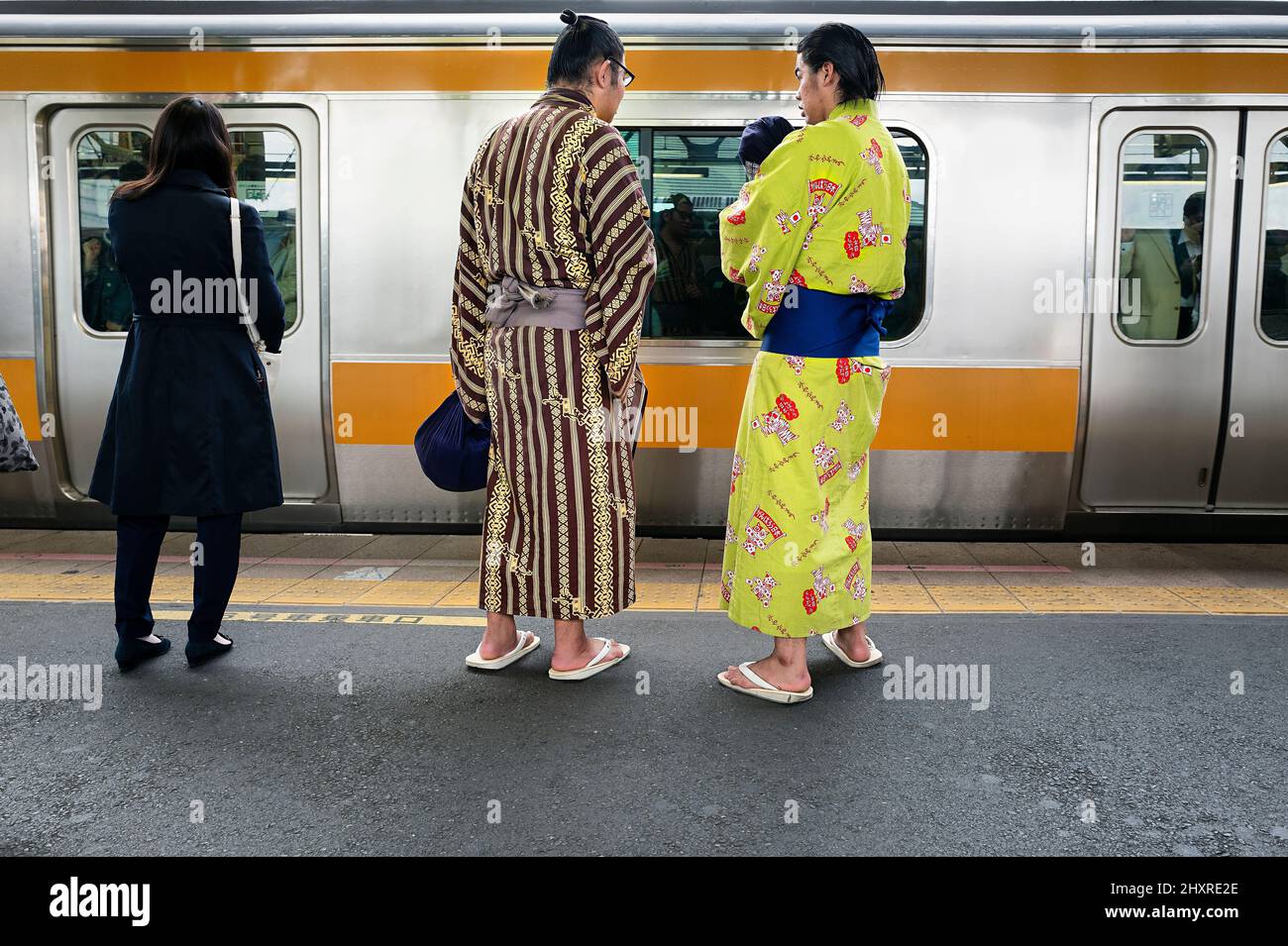 Giappone, Isola di Honshu, Kanto, Tokyo, apprendisti sumo in attesa su una piattaforma ferroviaria. Foto Stock