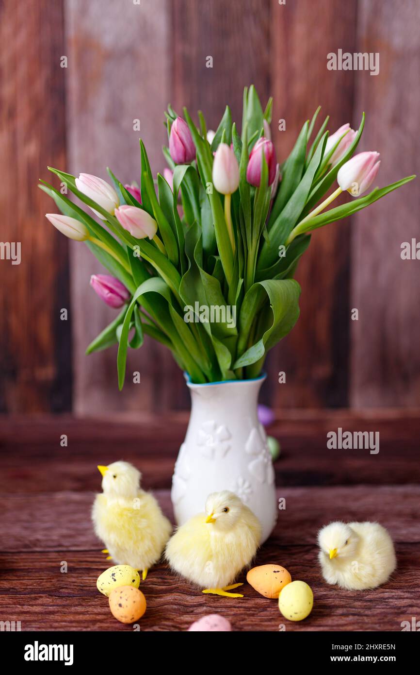 Pollo di Pasqua, uova e decorazione su sfondo di legno Foto Stock