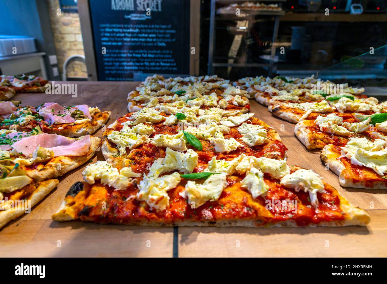 Fette di pizza margherita condita con mozzarella al ristorante siciliano Aromi, Cambridge, Cambridgeshire, Regno Unito Foto Stock