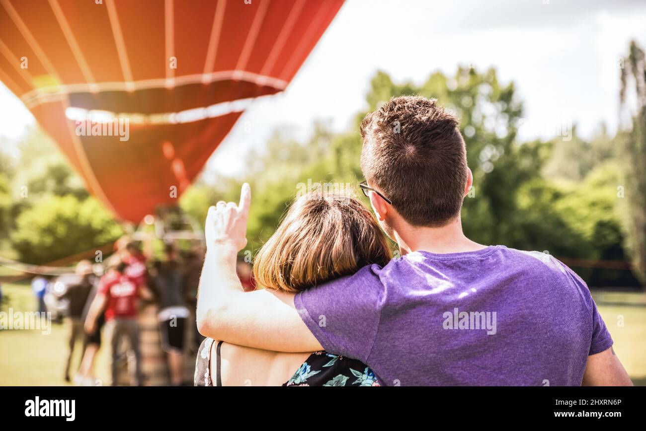 Felice coppia in amore per l'escursione in luna di miele in attesa di giro in mongolfiera - concetto di viaggio estivo con i giovani viaggiatori che si divertono a viaggio va Foto Stock