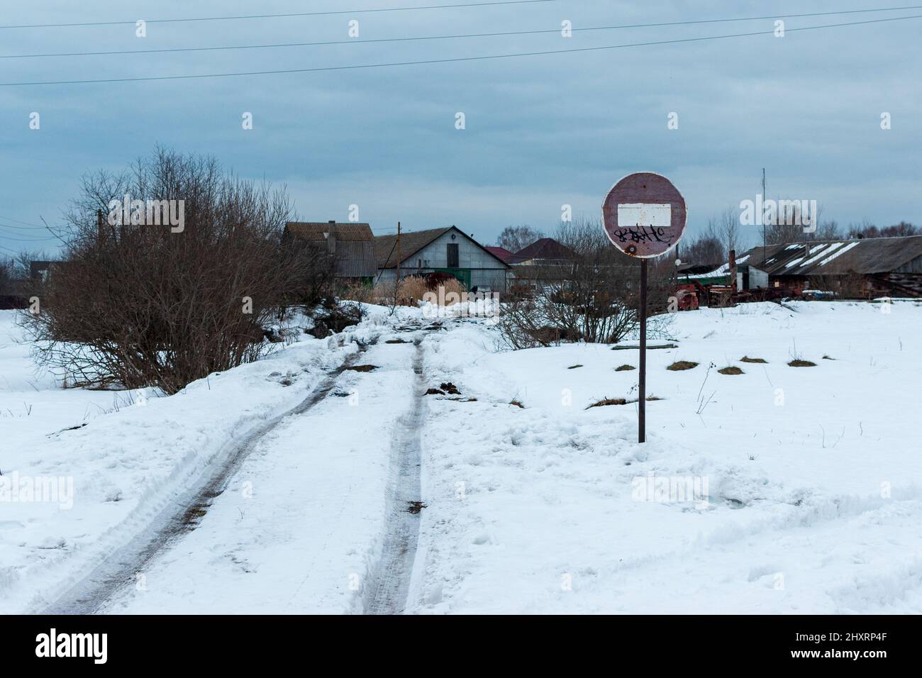 Vista di un vecchio segno meno arrugginito nel mezzo di una zona rurale o suburbana in inverno Foto Stock