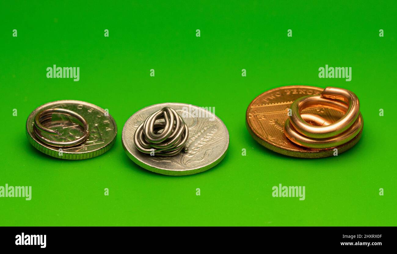 Primo piano di vecchie monete in acciaio, alluminio e rame isolate su sfondo verde Foto Stock