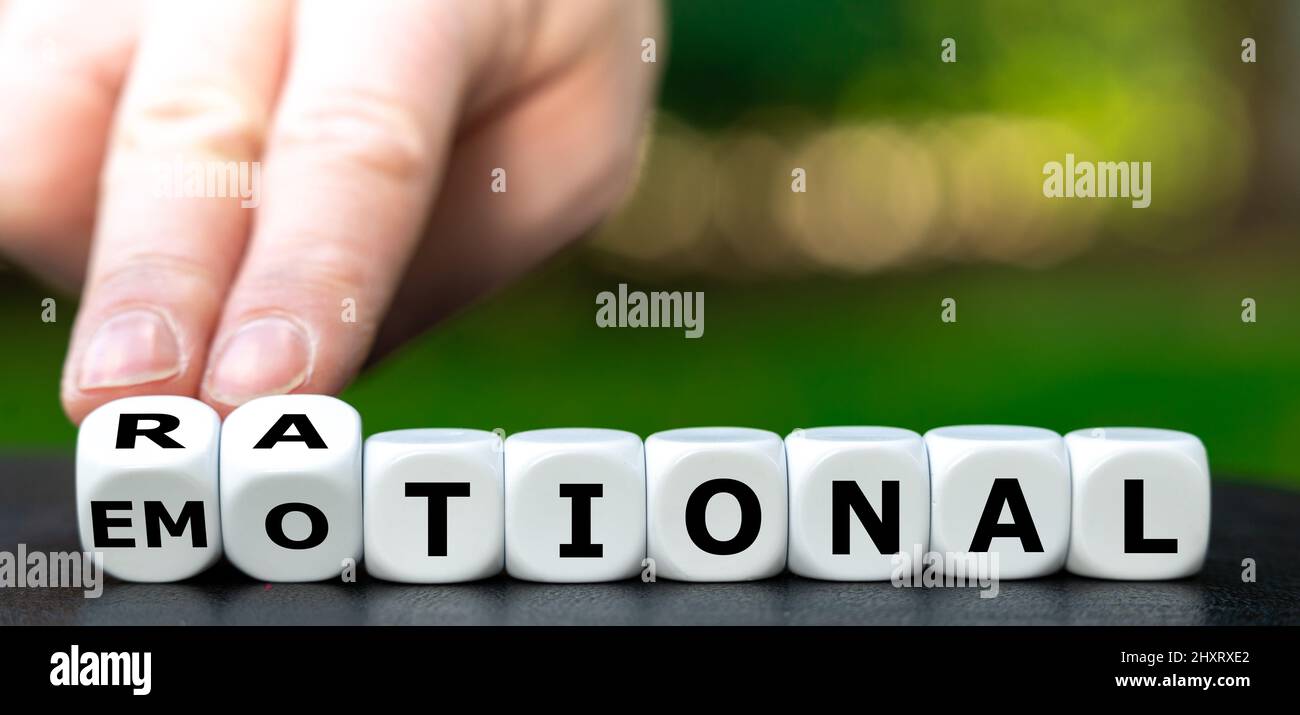 La mano gira i dadi e cambia la parola emotivo in razionale. Foto Stock
