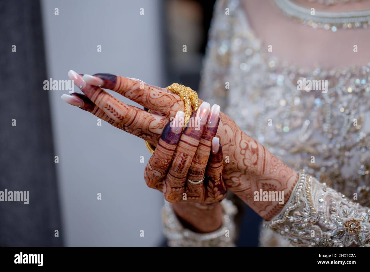 Closeup shot delle mani femminili indiane durante il suo giorno di nozze Foto Stock