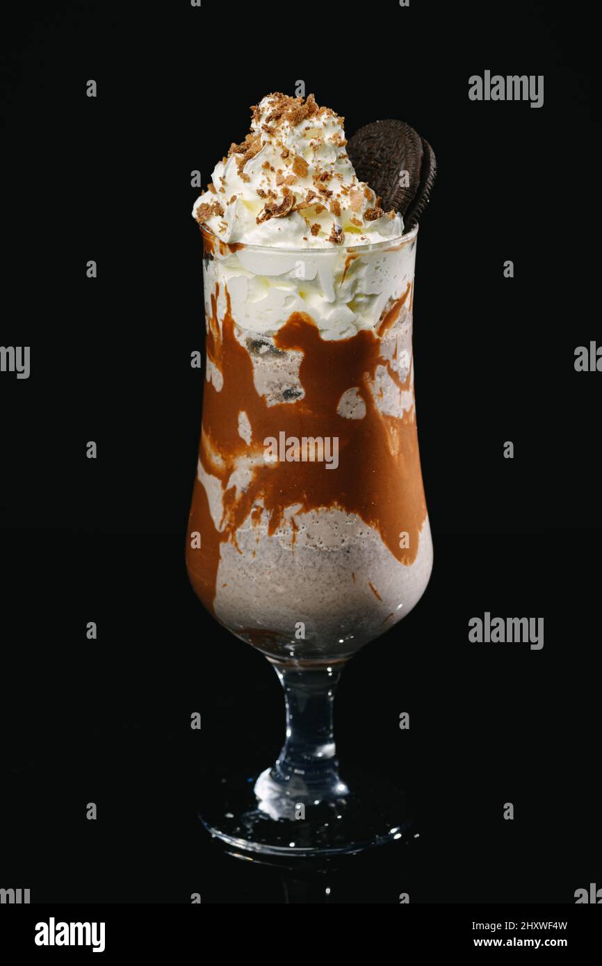 Colpo verticale di un milkshake al caramello su sfondo nero. Foto Stock