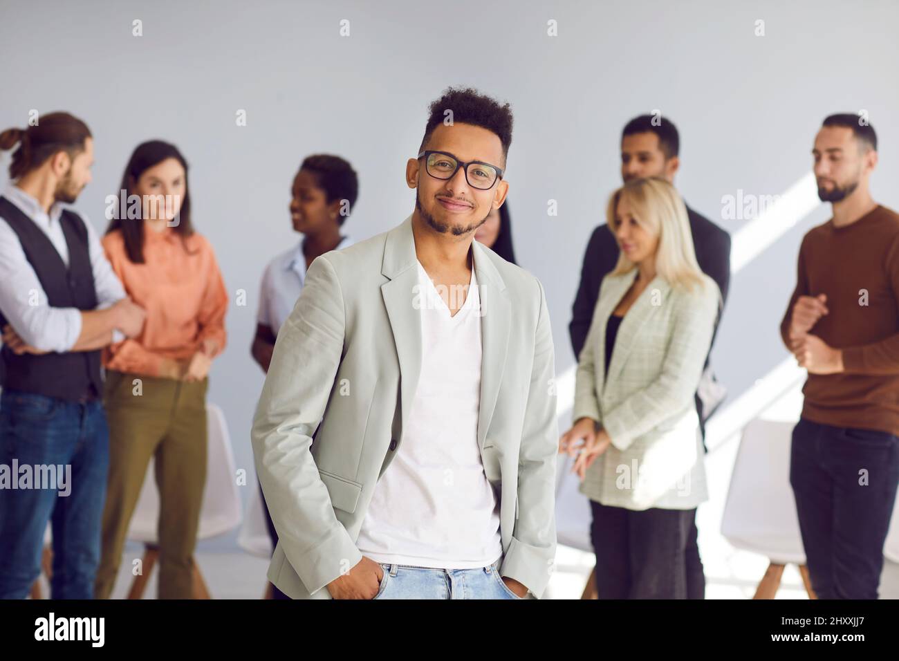 Ritratto del giovane business leader di fronte al suo team aziendale diversificato Foto Stock