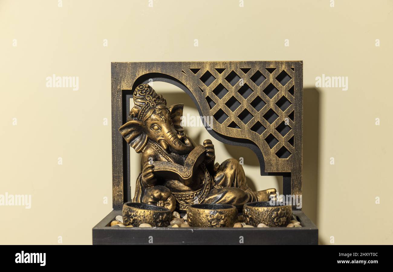 Primo piano della piccola scultura Lord Ganesha con candelieri Foto Stock