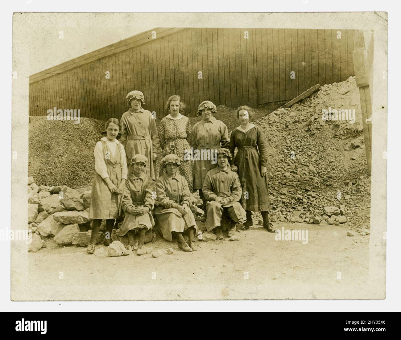 Originale fotografia del WW1 di gruppo di lavoratrici di cava, facendo il lavoro di uomini che sono andati a combattere in guerra. Le ragazze stanno indossando uniforme e seduto tra pietra di quarried. Runcorn, Cheshire, Regno Unito circa 1916. Foto Stock