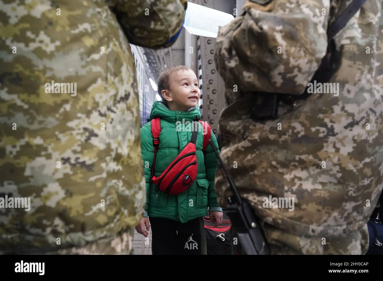 Lviv, Ucraina. 14th Mar 2022. Un bambino guarda avanti mentre i passaporti vengono controllati prima di abbaiare un treno per la Polonia, mentre i rifugiati ucraini si spostano attraverso la stazione ferroviaria di Lviv. Oltre 2,5 milioni di persone hanno lasciato l'Ucraina dall'inizio dell'invasione russa quasi tre settimane fa. (Credit Image: © Bryan Smith/ZUMA Press Wire) Foto Stock