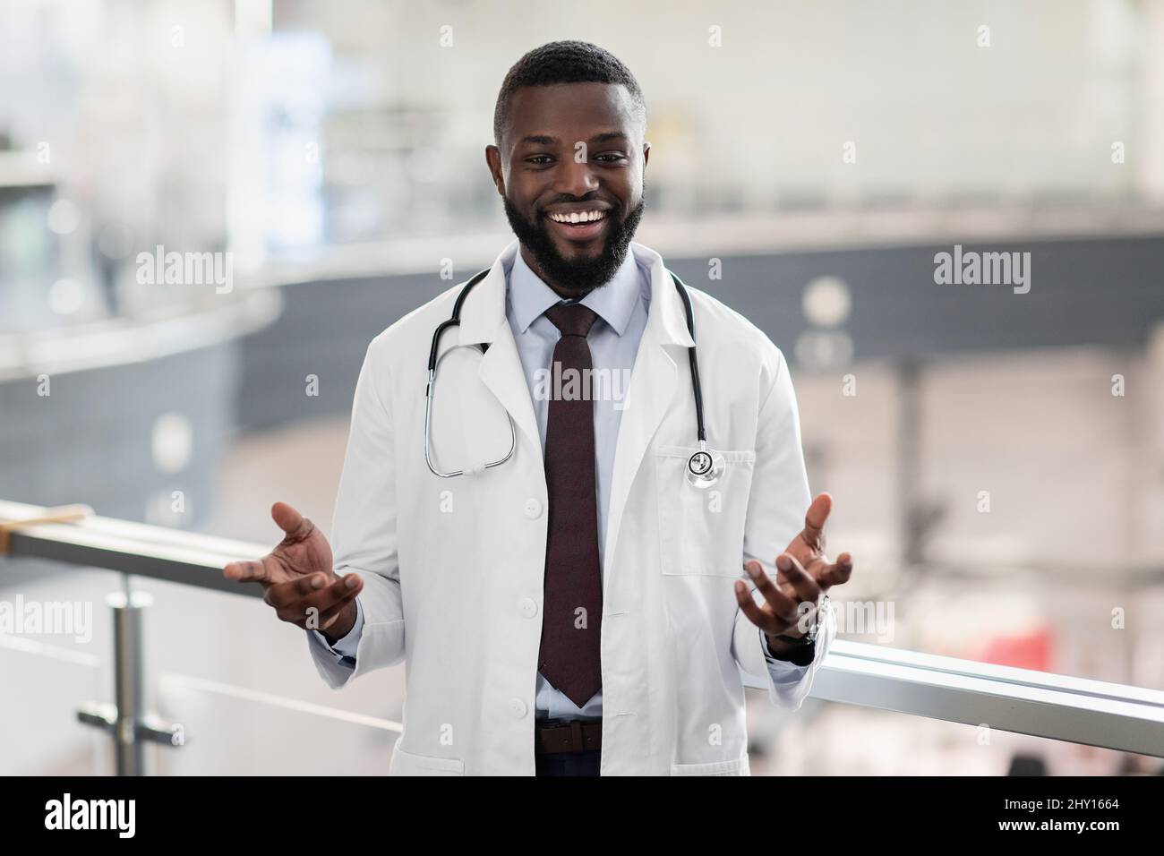Ritratto di allegro bel medico nero in posa in clinica Foto Stock