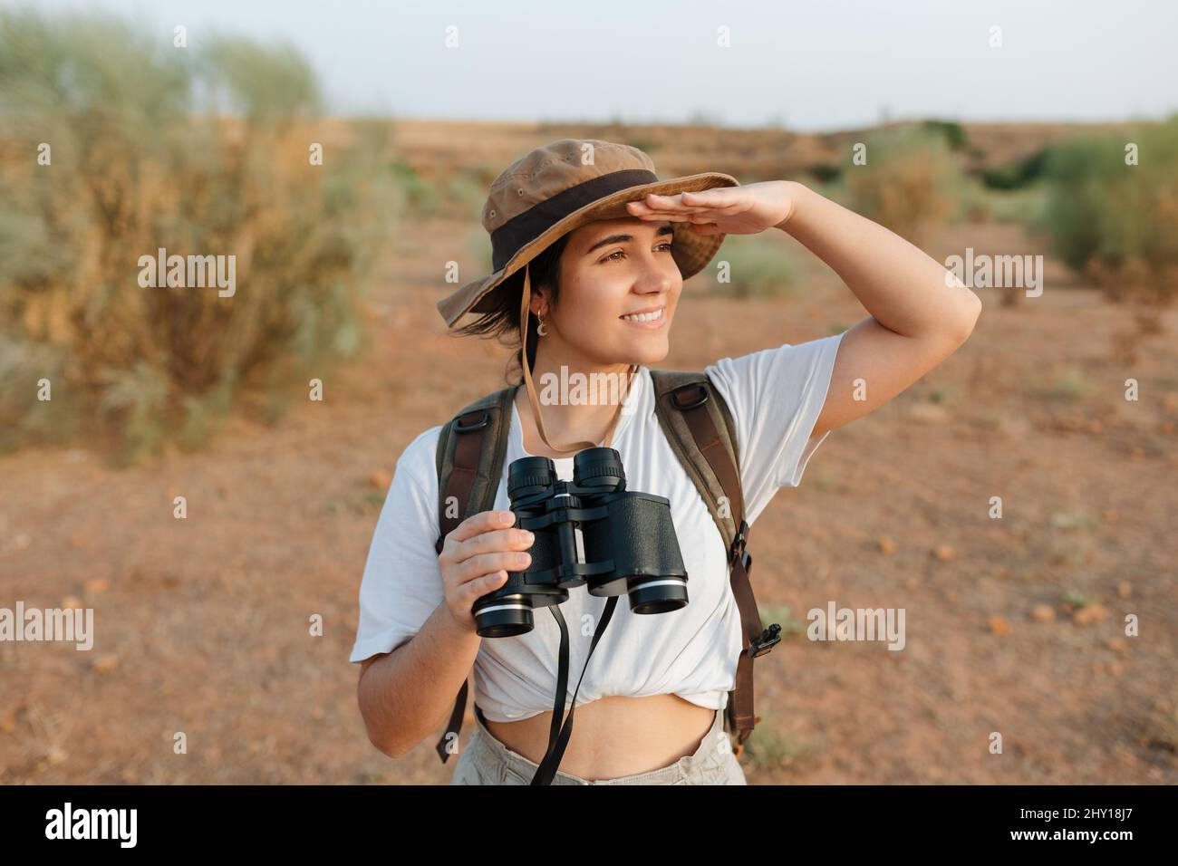 Attraente ragazza in maglione e hat con due mani incrociate vicino colle su sfondo sfocato nei Pirenei Foto Stock