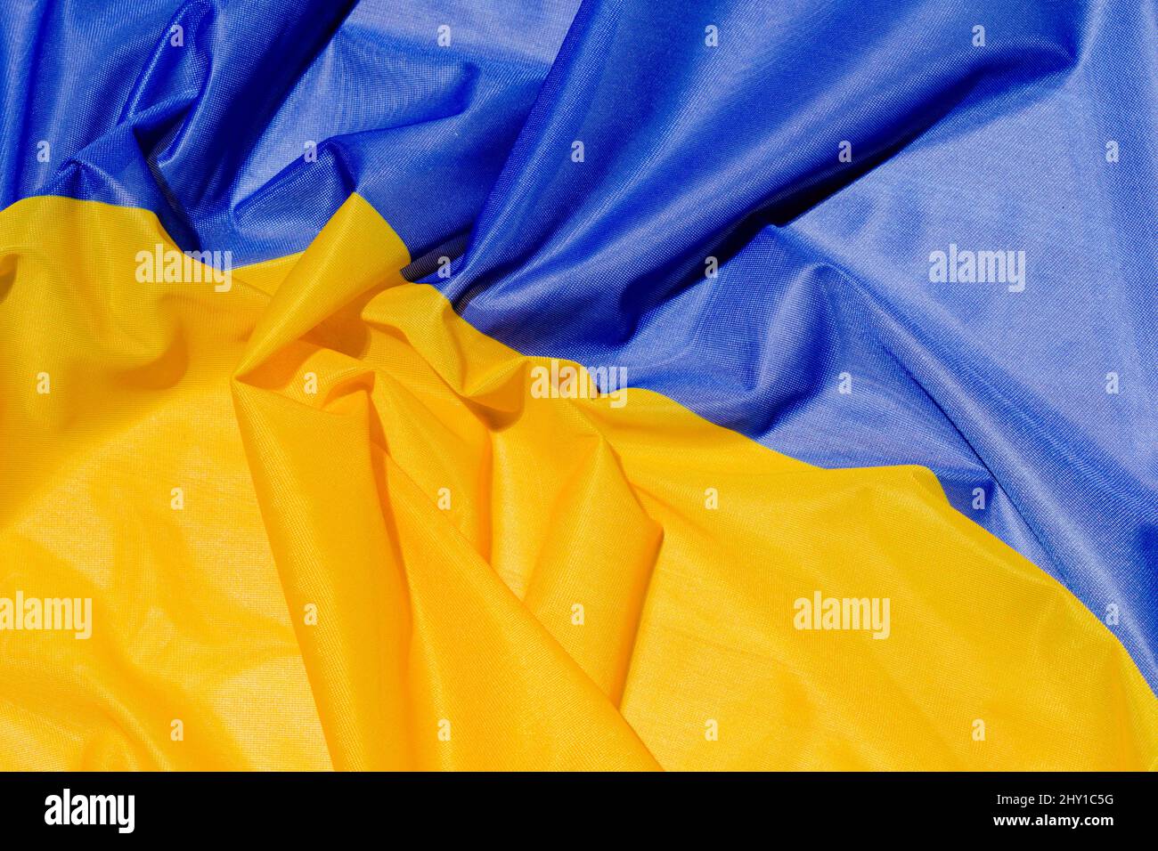 Sfondo pieno telaio di bandiera Ucraina nazionale colorata con tessuto gringiato e blu brillante con i colori gialli posti sulla superficie Foto Stock