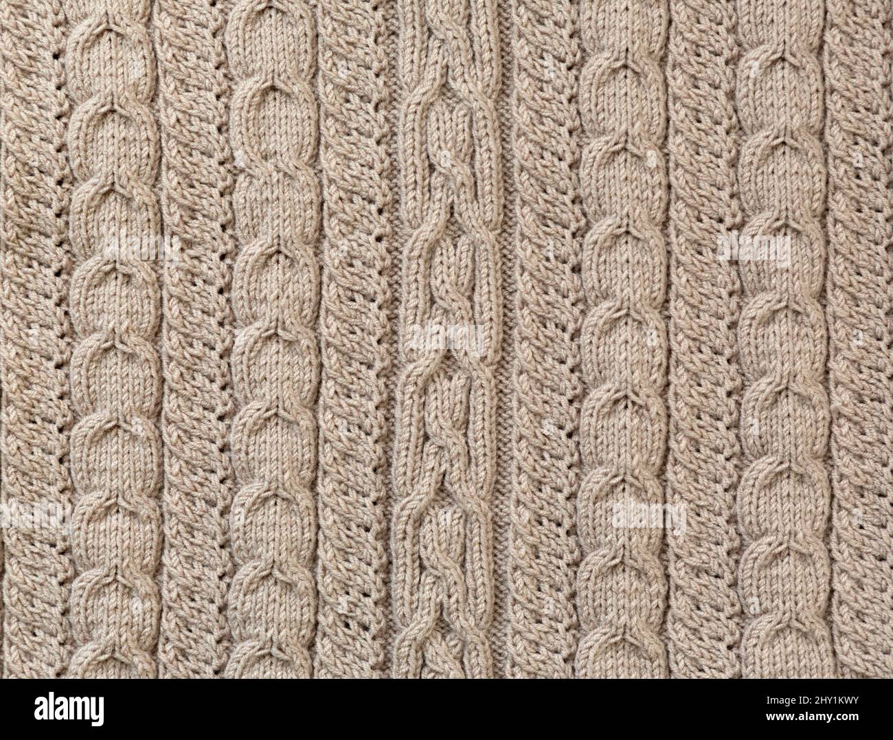 Modello di Unione. Primo piano di tessuto di lana lavorato a maglia. Il motivo marrone si unisce come sfondo. Foto Stock