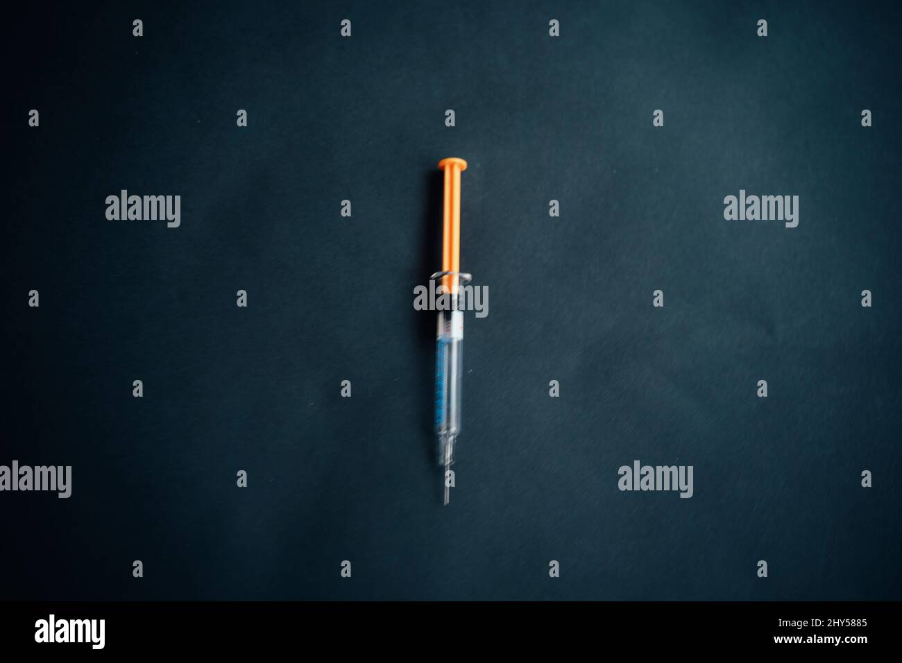 Vaccinazione: Siringhe con vaccini che formano una freccia su sfondo nero. Foto Stock