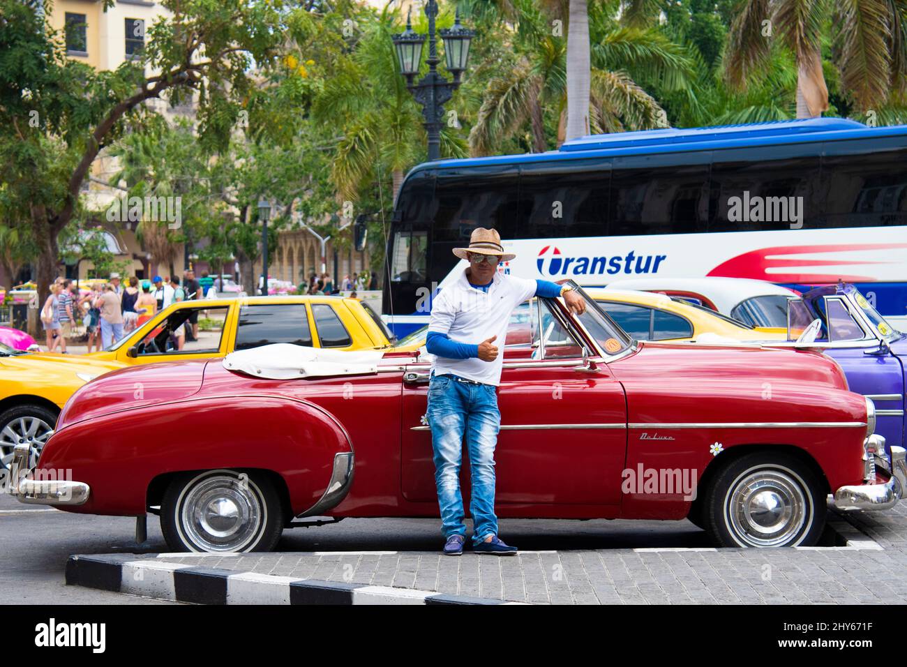 L'autista dà il cartello con i pollici davanti alla sua vecchia auto fatta in America per le strade di l'Avana, Cuba. Foto Stock