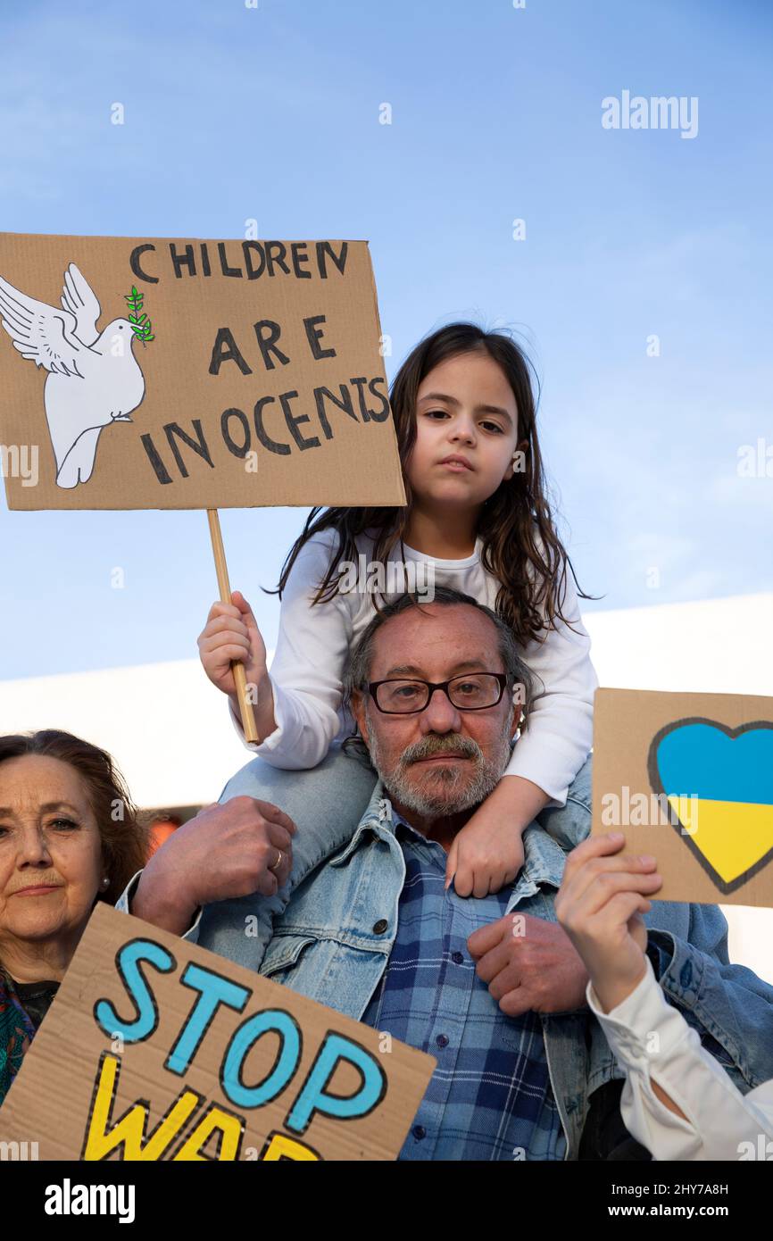 Gruppo di manifestanti di età diversa con bandiere anti-guerra. Protesta contro l'intervento russo in Ucraina, l'attivismo e il movimento per i diritti umani. Foto Stock