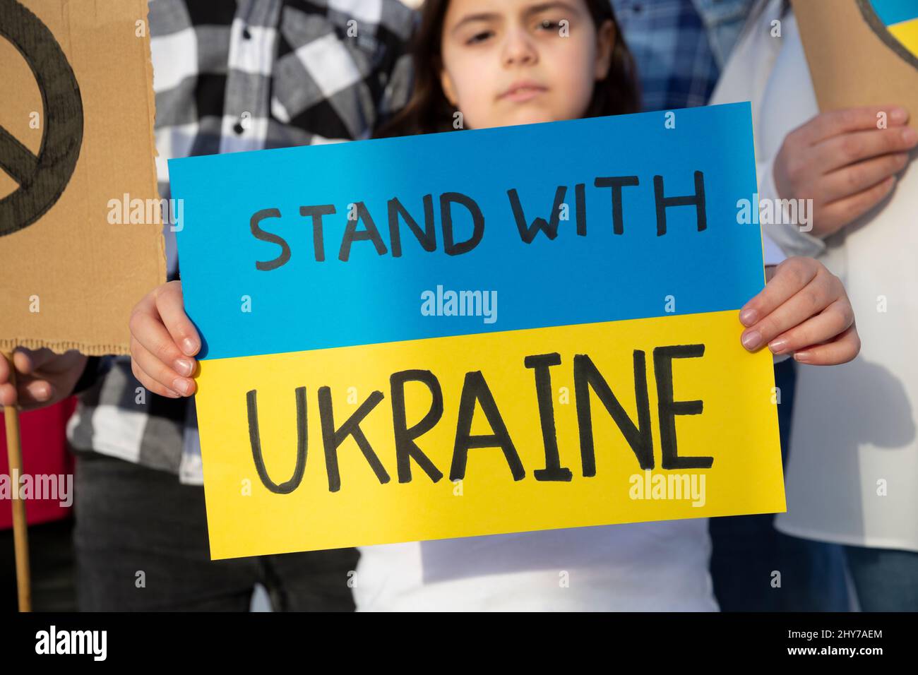 Bambino piccolo che tiene un segno con un messaggio di sostegno per il popolo ucraino. Manifestazione contro la guerra. Libera Ucraina. Foto Stock