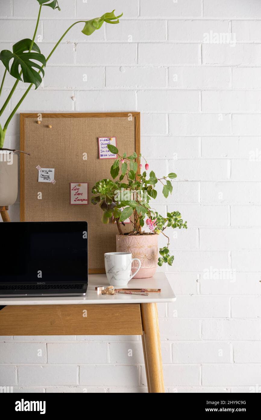 Una tazza di caffè sulla scrivania accanto al computer in un ufficio domestico. Foto Stock