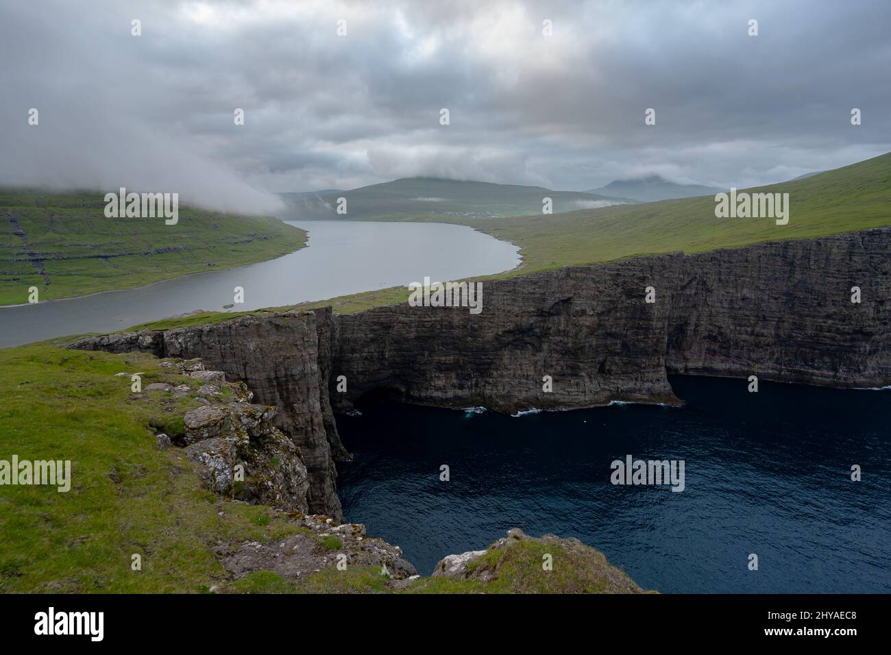 Splendida vista aerea della cascata di Bøsdalafossur e dei magnifici monumenti di Trælanípan nelle Isole Faroe Foto Stock
