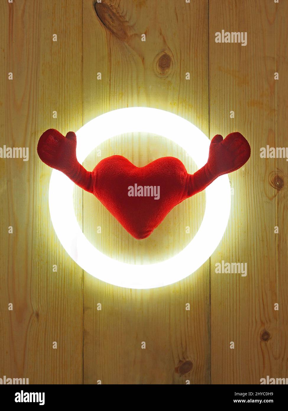 Cuore morbido con due mani isolate su sfondo rustico in legno Foto Stock