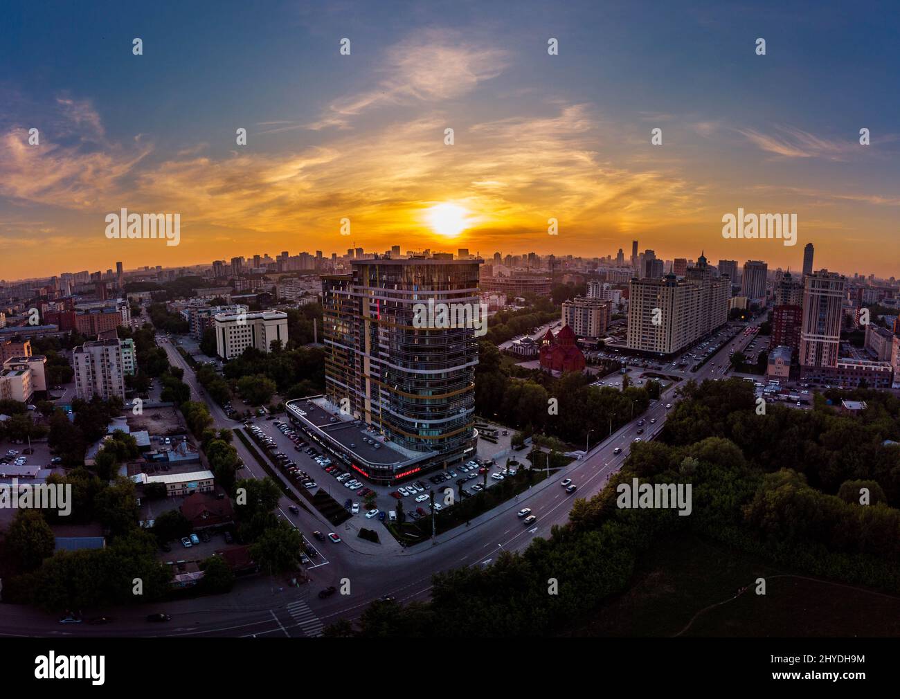Vista aerea della città di Ekaterinburg, edifici urbani e alberi verdi con cielo arancione tramonto Foto Stock