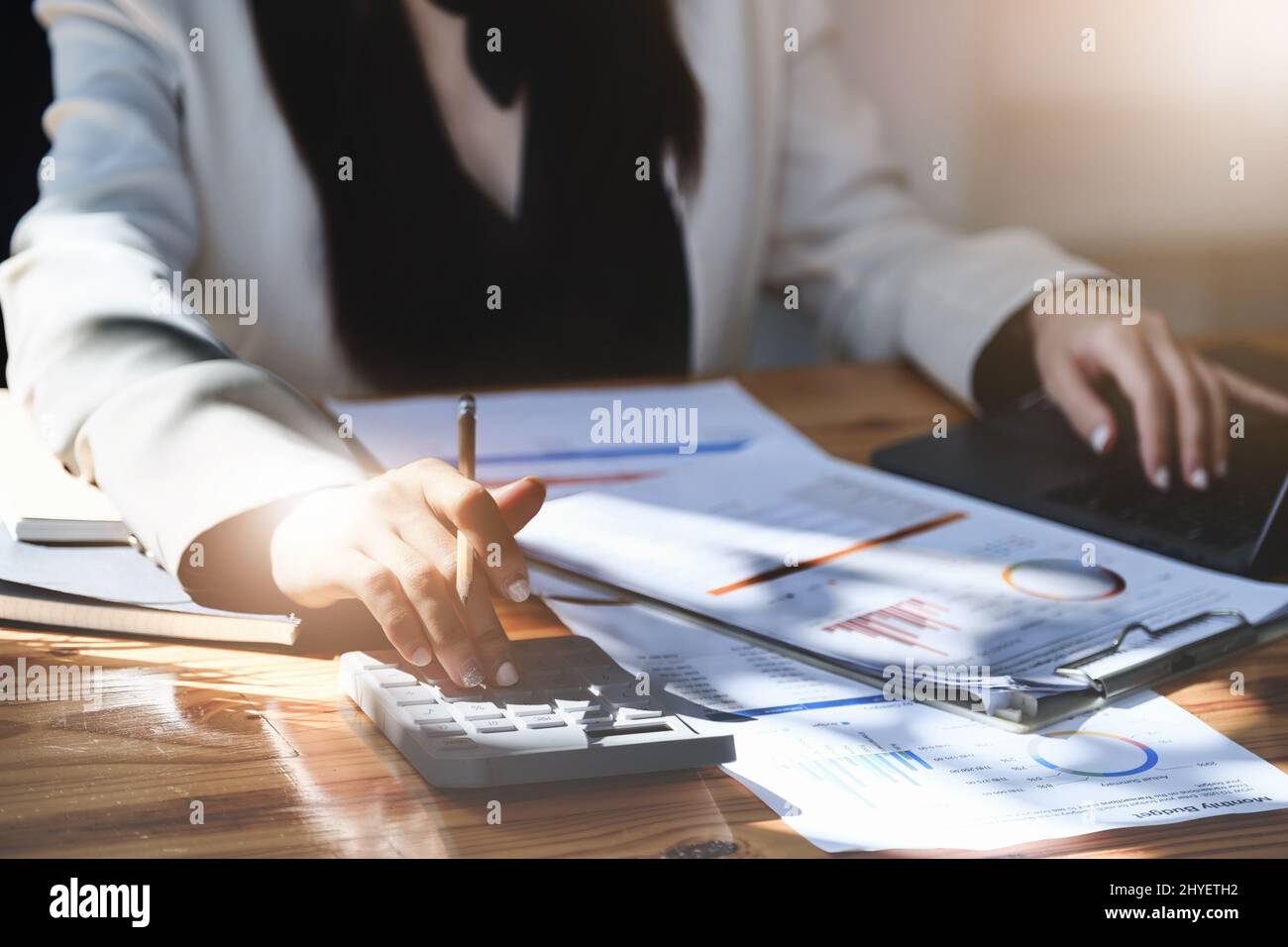 economisti e contabili , gli analisti di dati stanno usando le calcolatrici per calcolare i bilanci e gli investimenti usando i documenti statistici ed i calcolatori a. Foto Stock