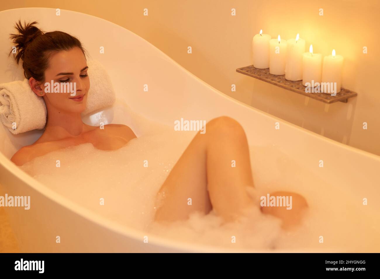 Il modo perfetto per concludere la giornata. Scatto ad angolo alto di una giovane donna attraente che prende un bagno di bolla. Foto Stock