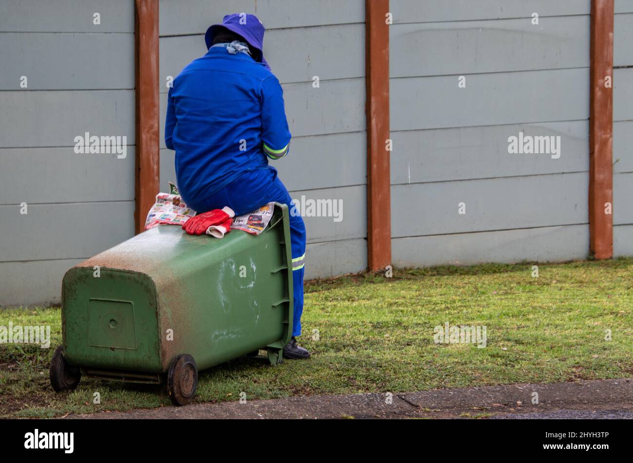 Johannesburg, Sudafrica - la donna di rifiuti non identificata si siede su un bidone che si trova tra le collezioni Foto Stock