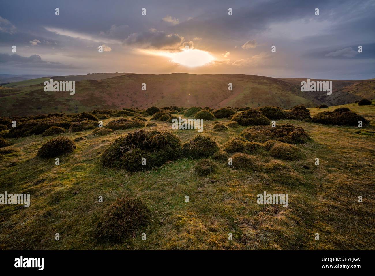 Il sole che si infrangono attraverso le nuvole tempestose su Clow Hill nelle Shropshire Hills, Inghilterra Foto Stock