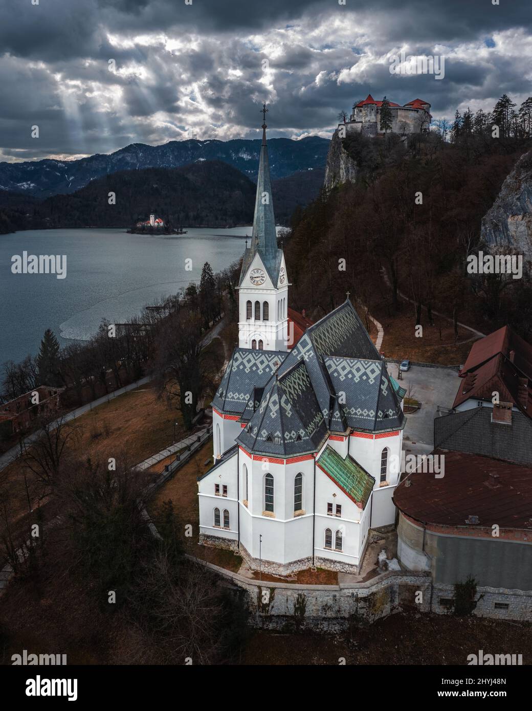 Bled, Slovenia - veduta panoramica aerea della Chiesa Parrocchiale di San Martino con il Castello di Bled (Blejski Grad), l'Isola di Bled e le Alpi Giulie sullo sfondo Foto Stock