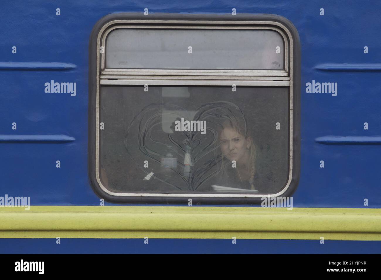 2022-03-03 13:46:39 una giovane ragazza arriva da Kiev alla stazione ferroviaria di Lviv su un treno che porta il colore del paese. Alcuni dicono che il viaggio a Lviv da Kiev dura fino a 17 ore a causa dei punti di controllo e di un sistema ferroviario sovraccarico. La gente fugge dall'Ucraina, assediata dalla Russia. ANP / altezza olandese / Warren Richardson Foto Stock