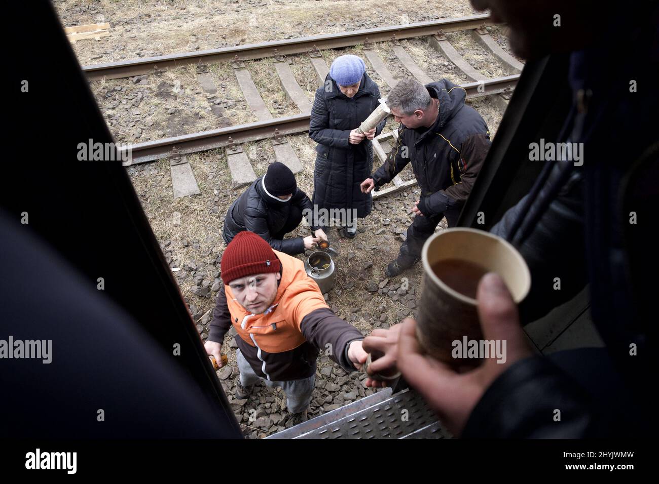 Lviv, Ucraina. I volontari si fermano sul lato dei binari mentre il treno si ferma in attesa di raggiungere il confine polacco, l'acqua alimentare e le bevande calde vengono rapidamente spillate nel treno per aiutare ad accomodarsi. ANP / Hollandse Hoogte / Warren Richardson Foto Stock