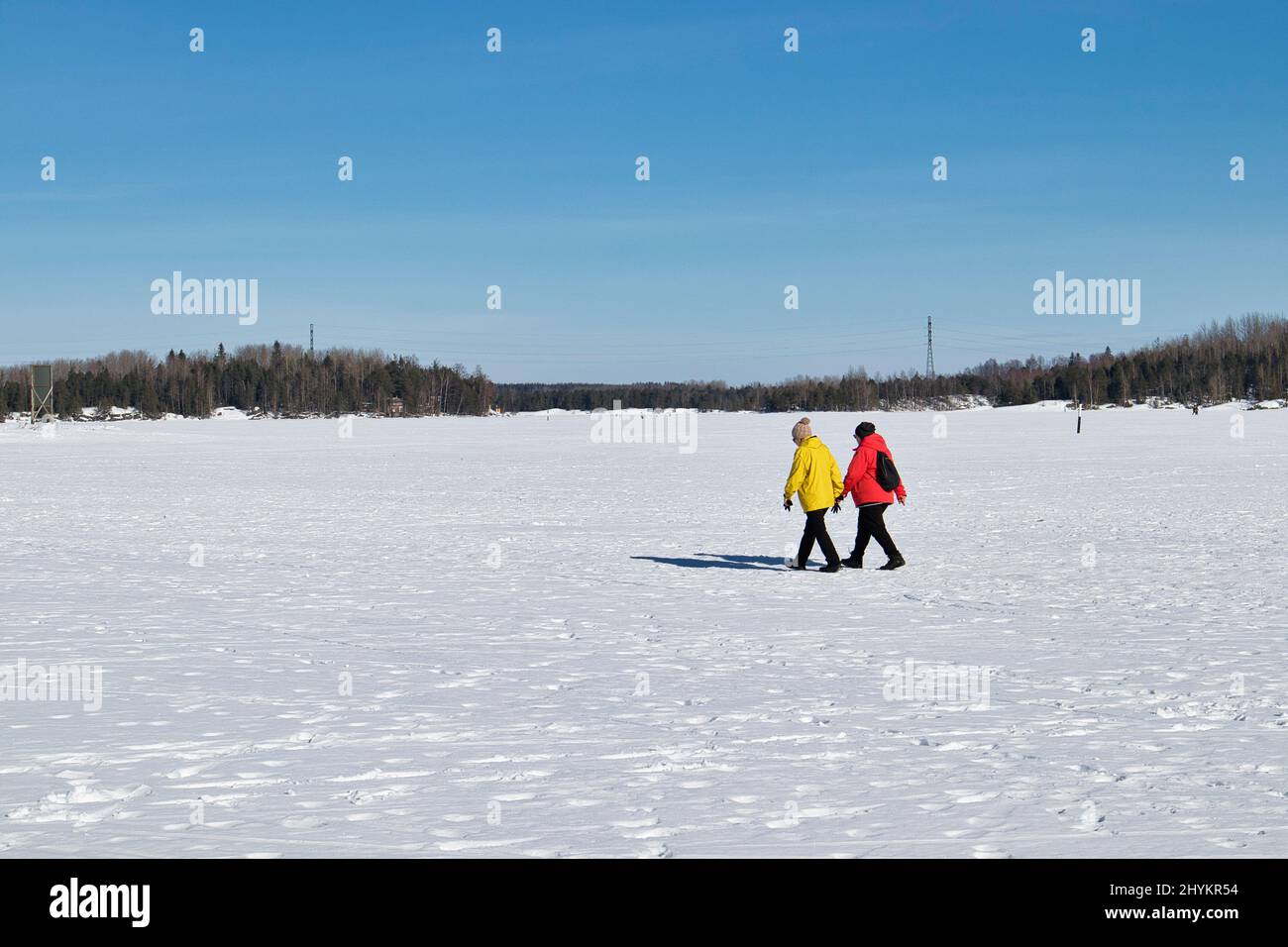 Due donne anziane che camminano sul lago ghiacciato Saimaa, Lappeenranta Finlandia Foto Stock