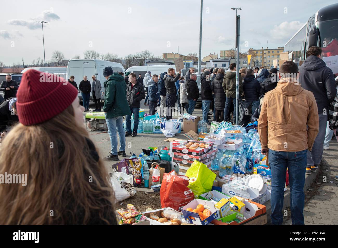 I rifugiati ucraini, gli aiutanti distribuiscono cibo, bevande e vestiti, i volontari sono venuti con i minibus e trasportano i rifugiati ulteriormente in differenti Foto Stock