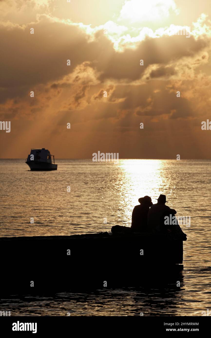 Silhouette di jetty, coppia e barca, tramonto dietro la nuvola, Mar dei Caraibi, hotel, Bungalow resort, Maria la Gorda, provincia Pinar del Rio, Cuba Foto Stock