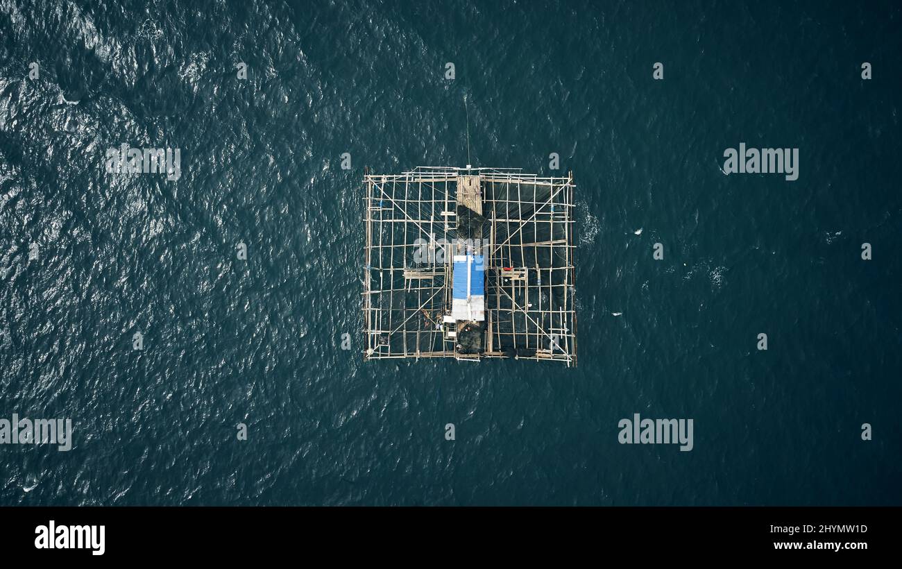 Un kelong è la cosa più vicina a lavorare da casa. Colpo ad angolo alto di una struttura di pesca costruita che galleggia nel mezzo dell'oceano chiamato un kelong. Foto Stock