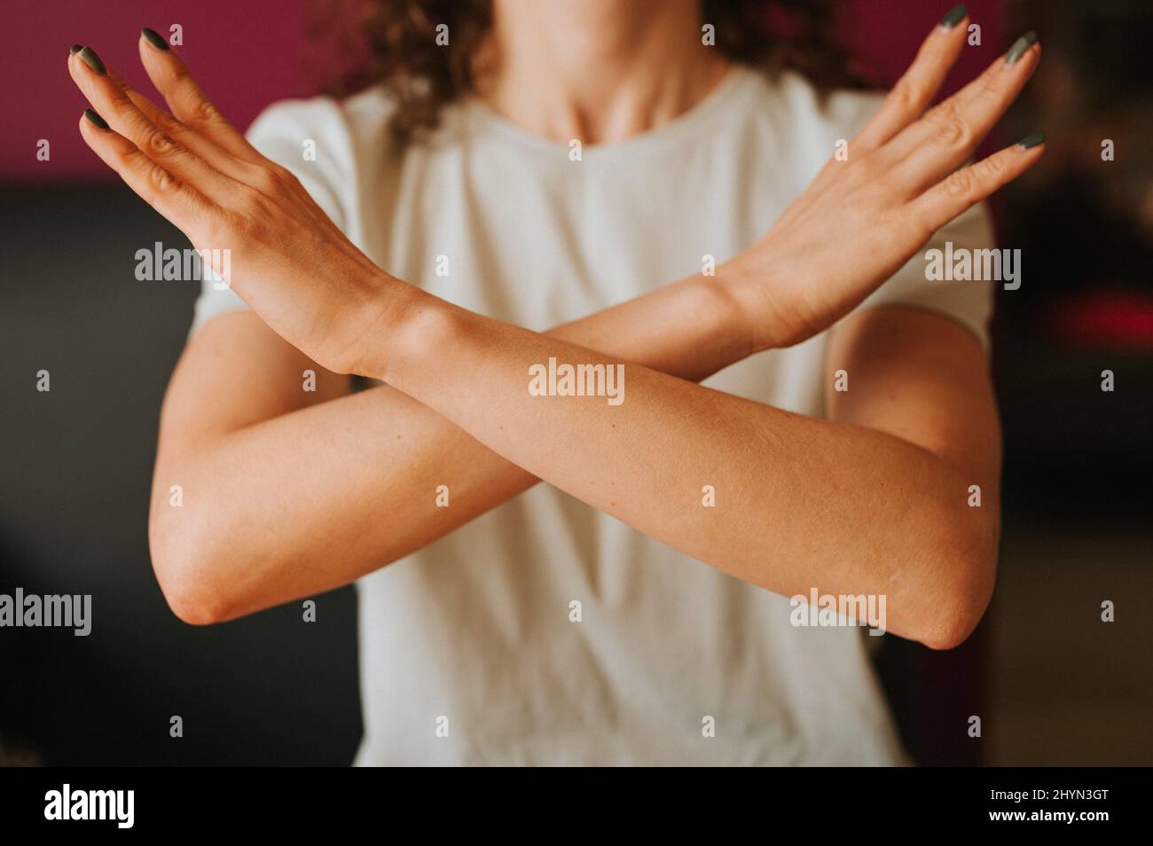 la giovane donna con le braccia incrociate al petto dimostra rompere il simbolo di bias della giornata internazionale delle donne iwd 8 marzo concetto di femminismo, pari di genere Foto Stock