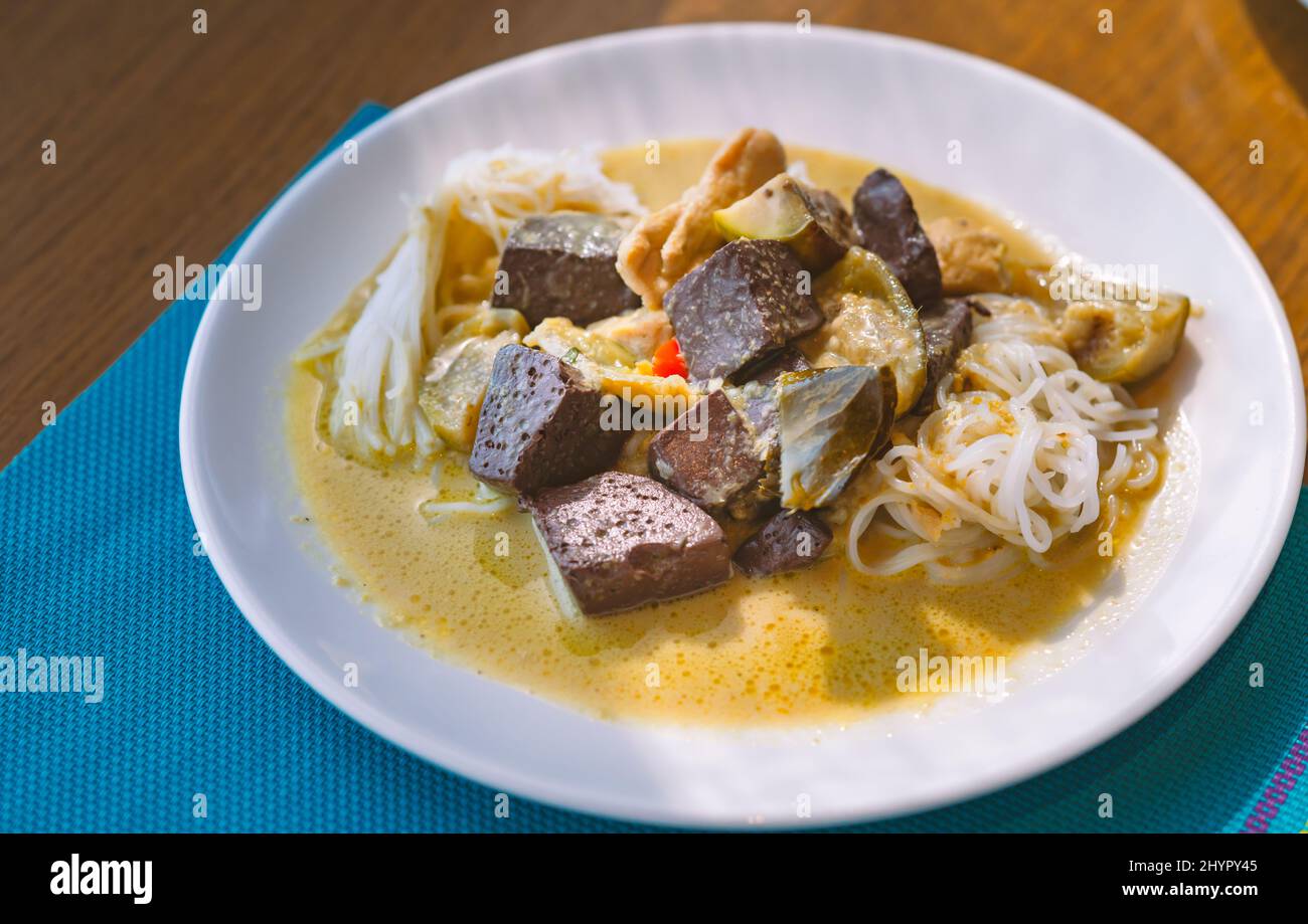Spaghetti di riso lievemente fermentati o Cheen Kanom in lingua thailandese, spaghetti con pollo al curry verde e sangue di pollo in streaming, cibo in roun bianco Foto Stock