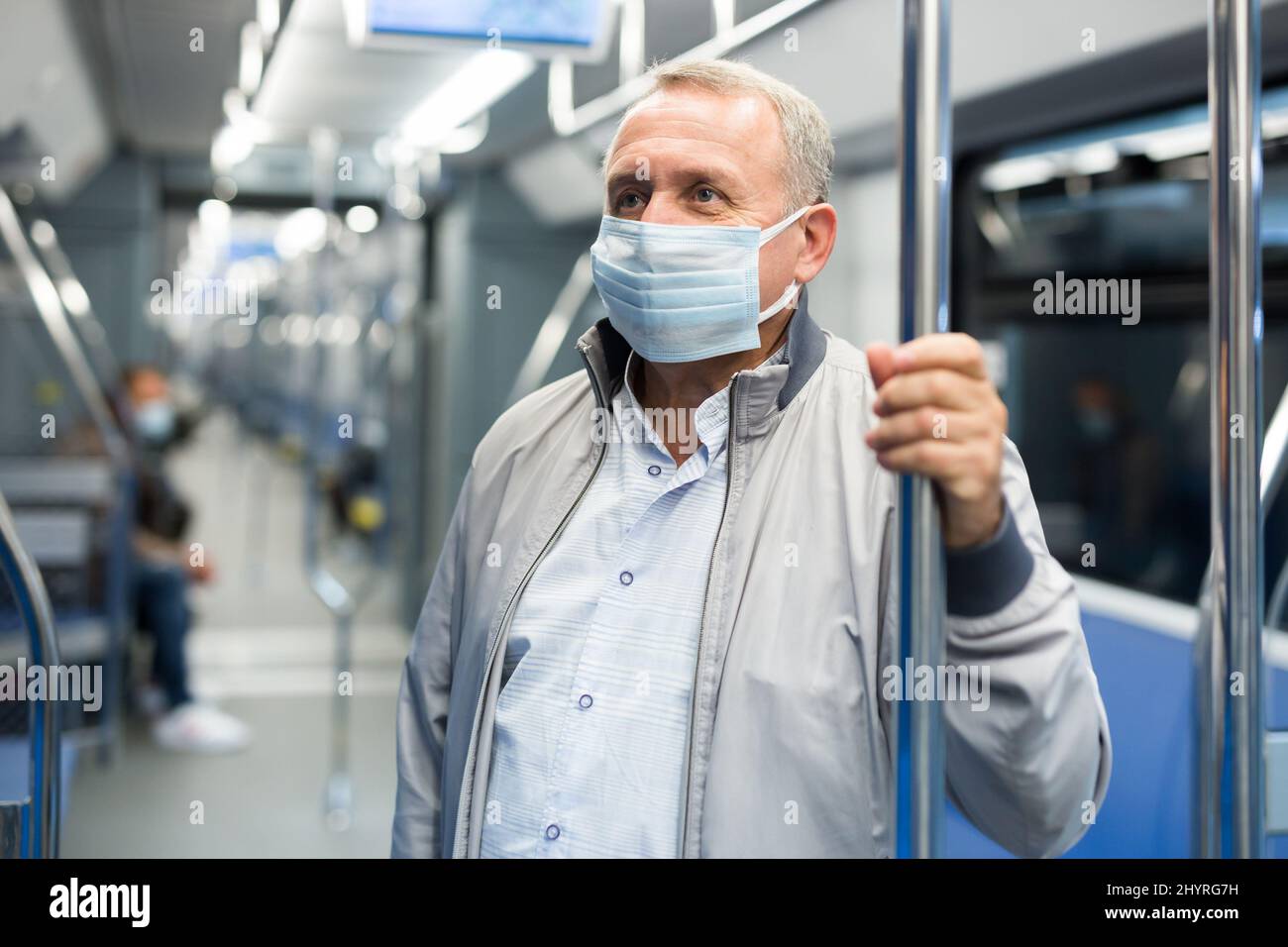 Uomo di mezza età in maschera in metropolitana Foto Stock