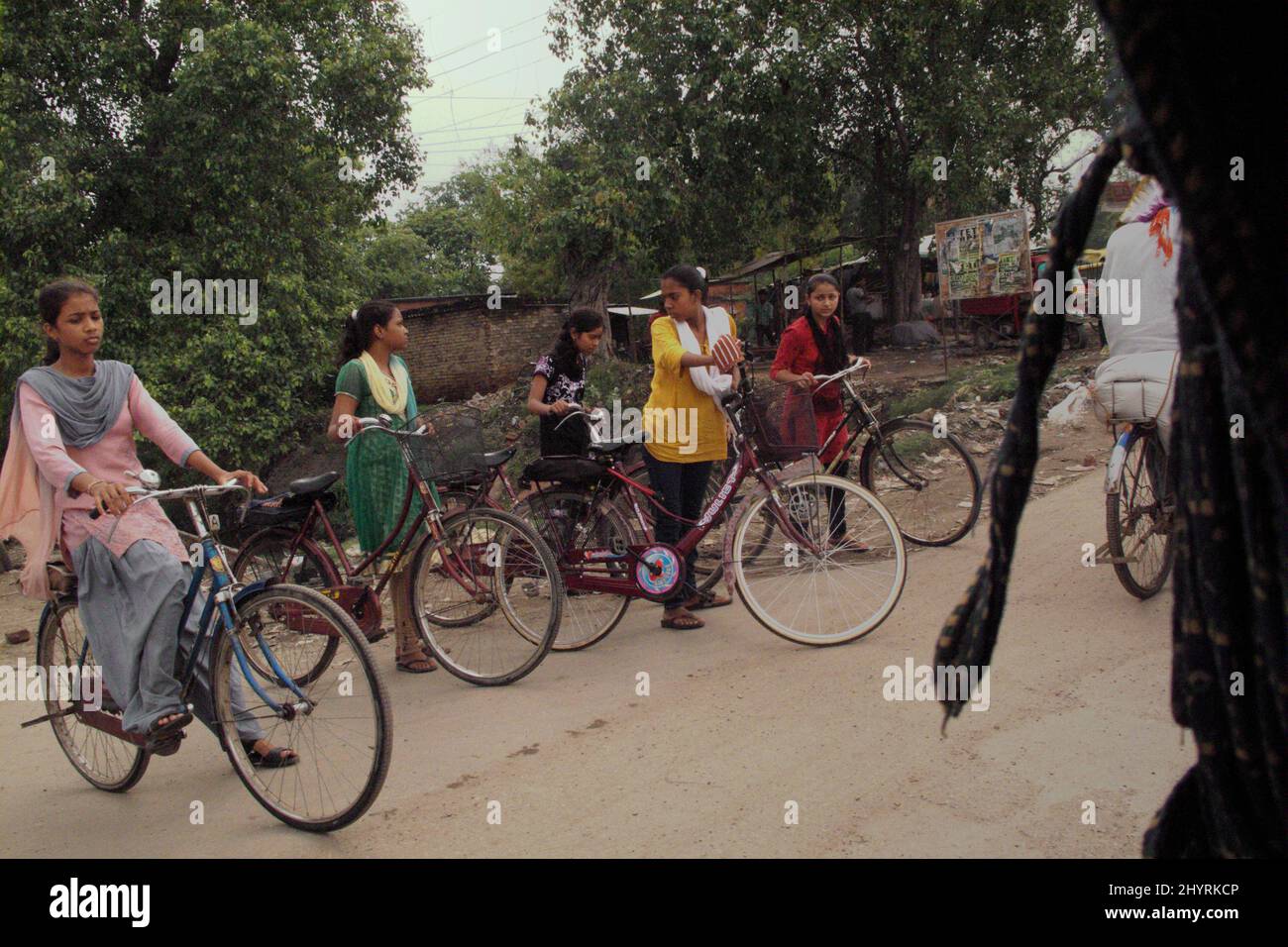 Ragazze in età scolare in attesa di attraversare una strada trafficata mentre stanno andando in bicicletta a Varanasi, Uttar Pradesh, India. Utttar Pradesh ha la più alta iscrizione tra gli stati dell'India, secondo All India Survey on Higher Education (AISHE) 2019-20 rilasciato lo scorso anno (2021), come citato da Times of India il 11 giugno 2021. Utttar Pradesh ha il 50,9% di studenti di sesso femminile e il 49,1% di studenti di sesso maschile si iscrive nel paese, ha detto il rapporto. Foto Stock